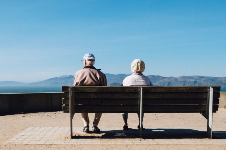 老夫婦がベンチで風景を見ている